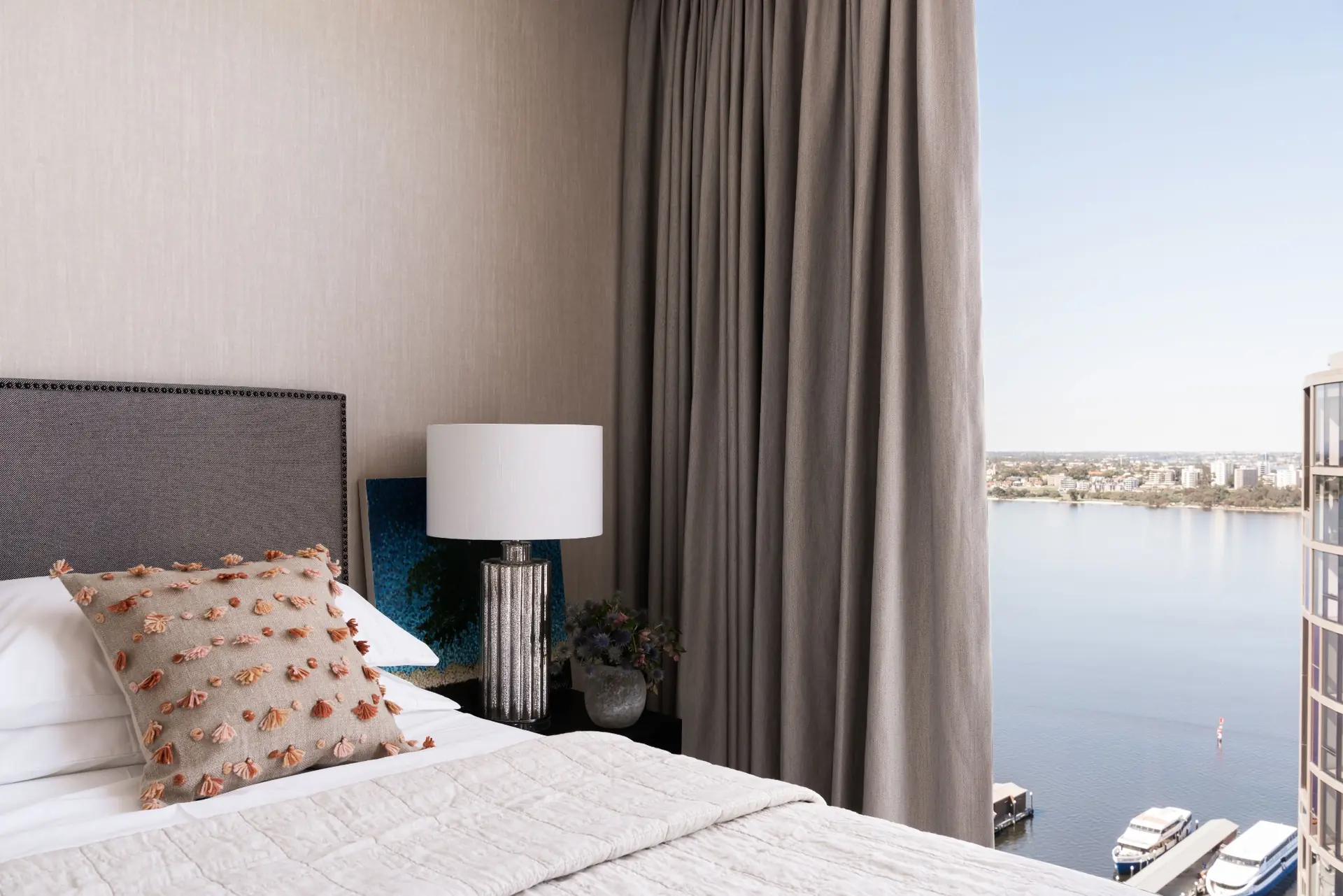 Upholstered bedhead with river-view window in Elizabeth Quay Ritz-Carlton apartment, Perth